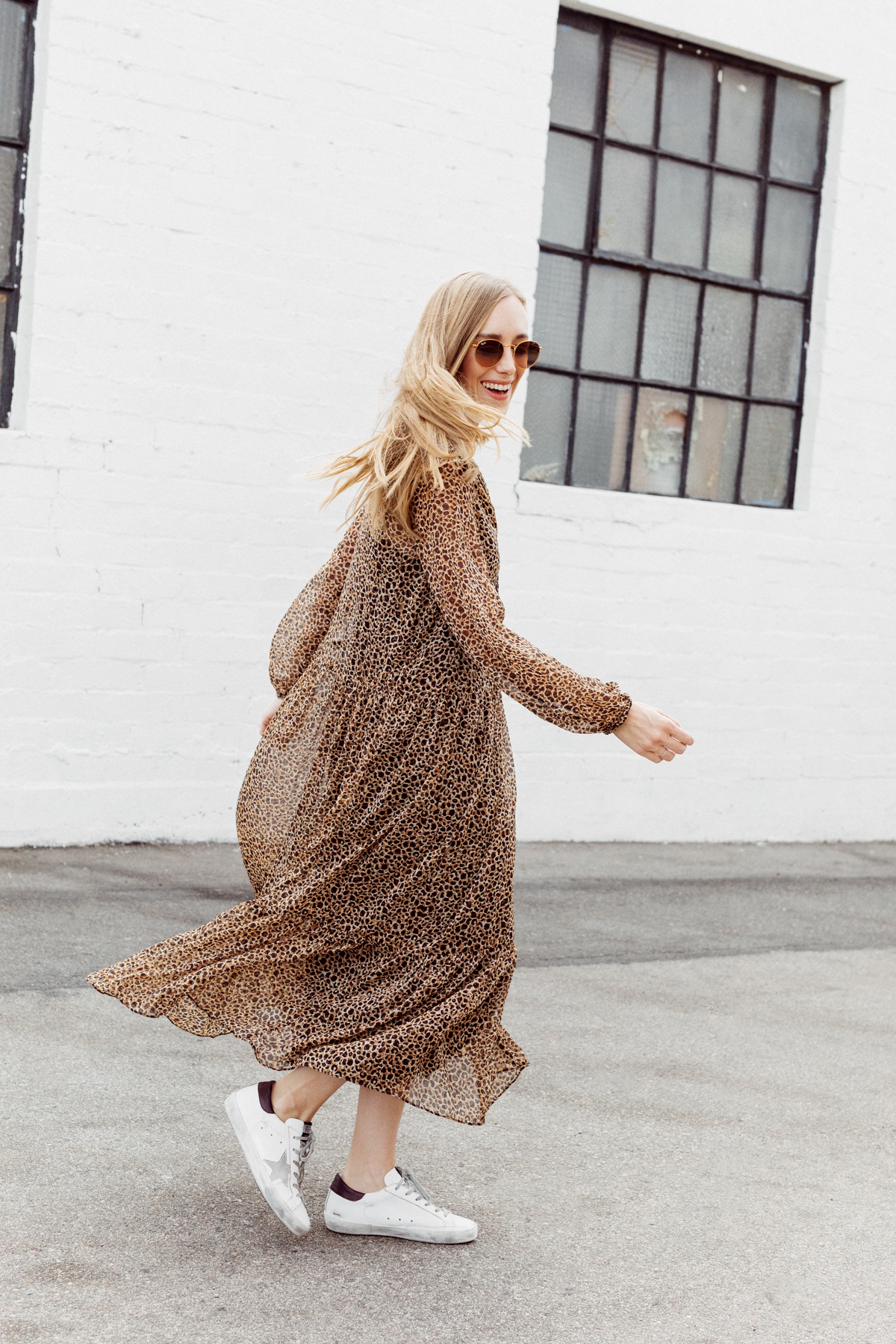 Kimberly Lapides of eatsleepwear wearing a long leopard maxi dress from h&m and golden goose sneakers with ray-ban sunglasses.