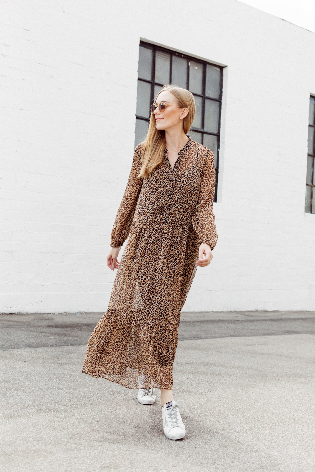 Kimberly Lapides of eatsleepwear wearing a long leopard maxi dress from h&m and golden goose sneakers with ray-ban sunglasses.