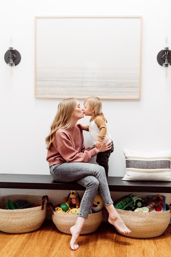 Kids toys organized in Citizenry baskets under an entryway bench by Kimberly Lapides of eatsleepwear