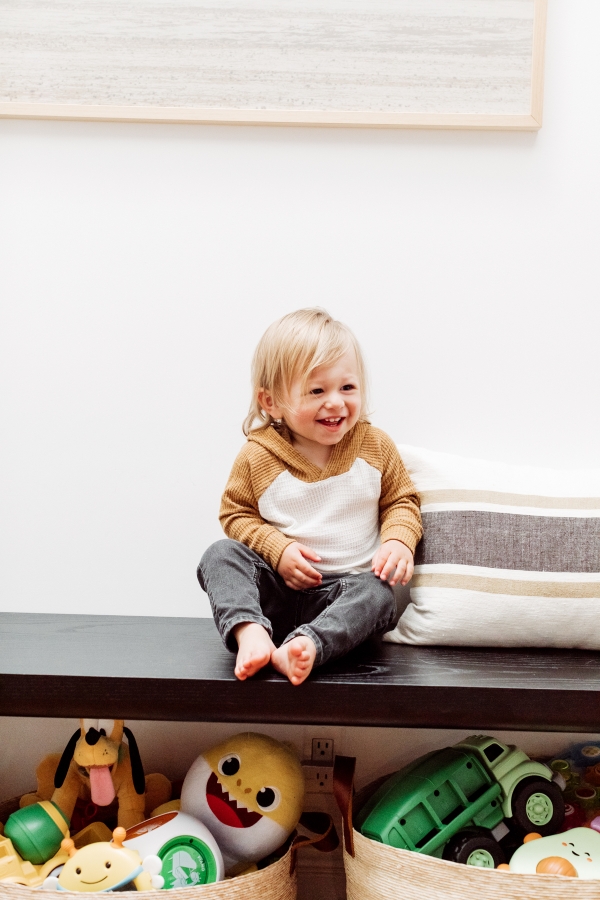 Toddler laughing with his chic toy baskets by Kimberly Lapides of eatsleepwear