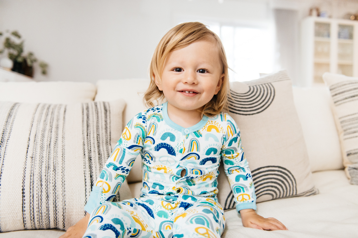 toddler on couch wearing Clover Baby & Kids pajamas celebrating Rainbow Baby, IVF, and Infertility