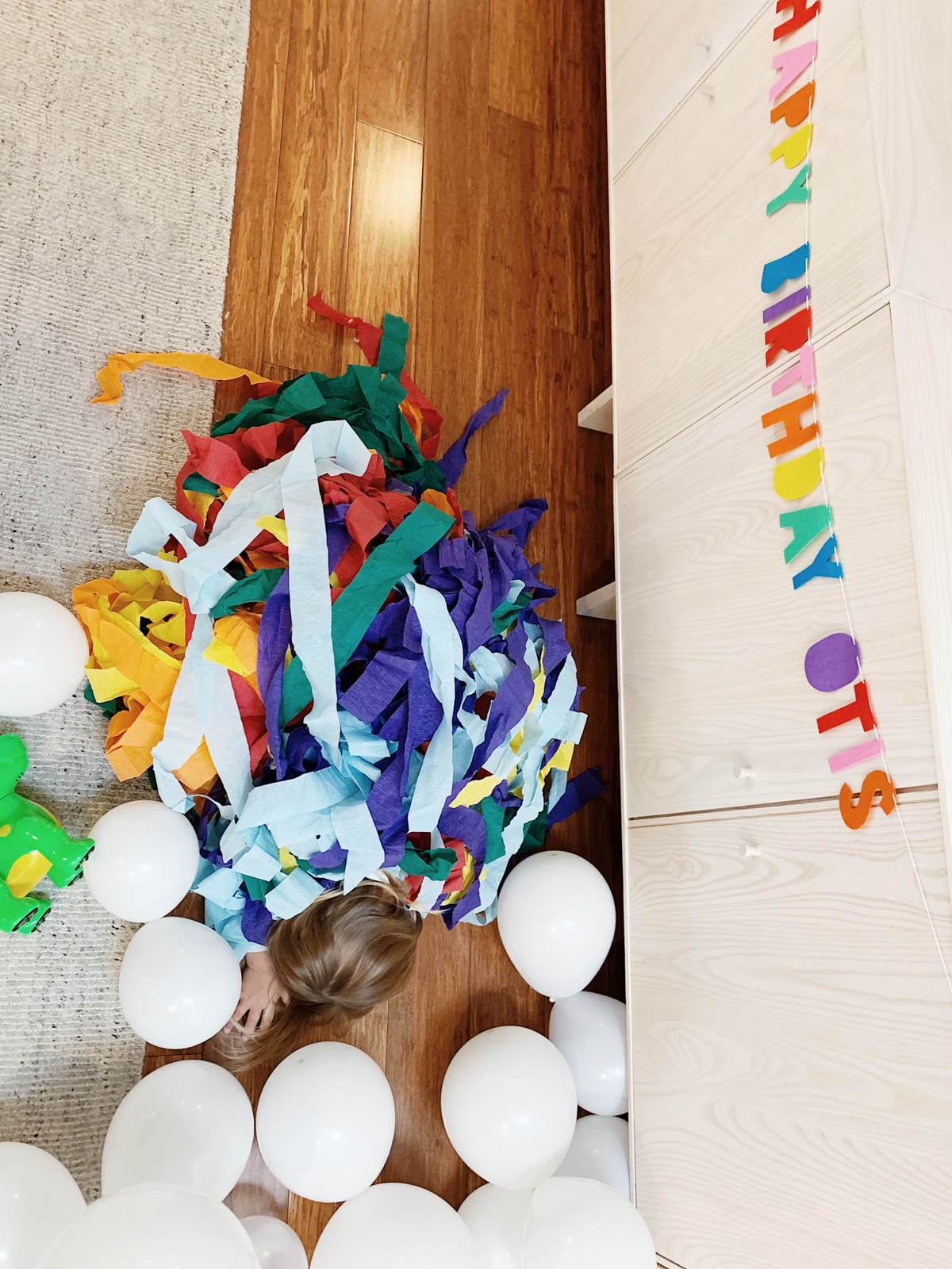 Toddler running with streamers from Trolls theme birthday