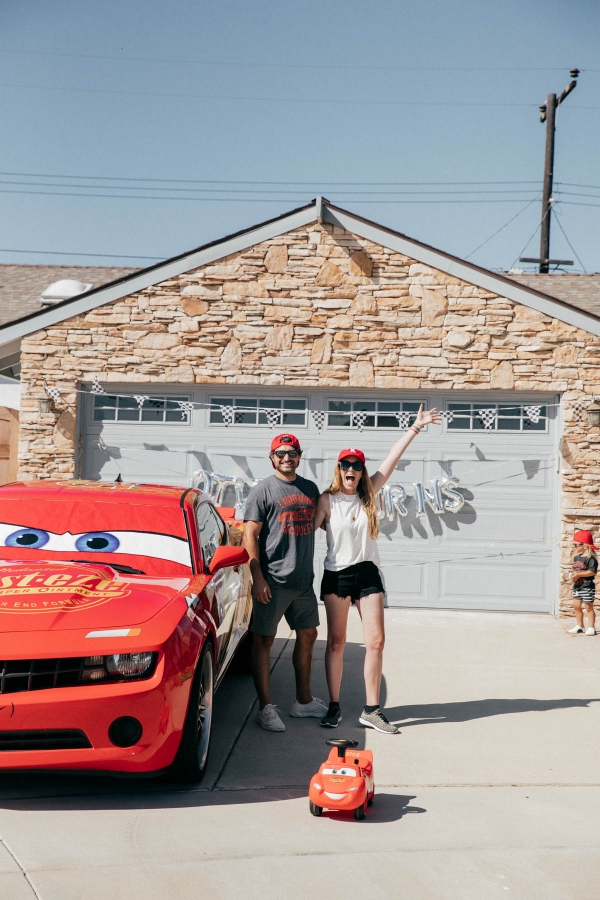 Parents being silly while toddler is shy at Disney Pixar Cars themed birthday