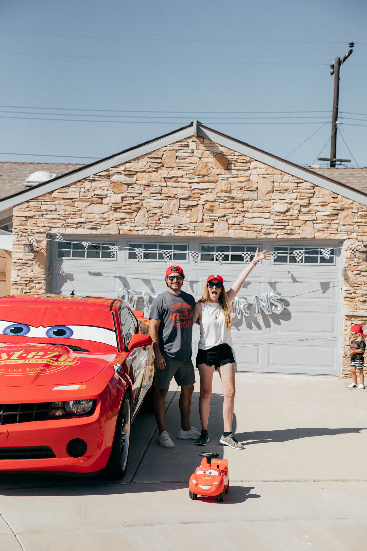 Parents being silly while toddler is shy at Disney Pixar Cars themed birthday