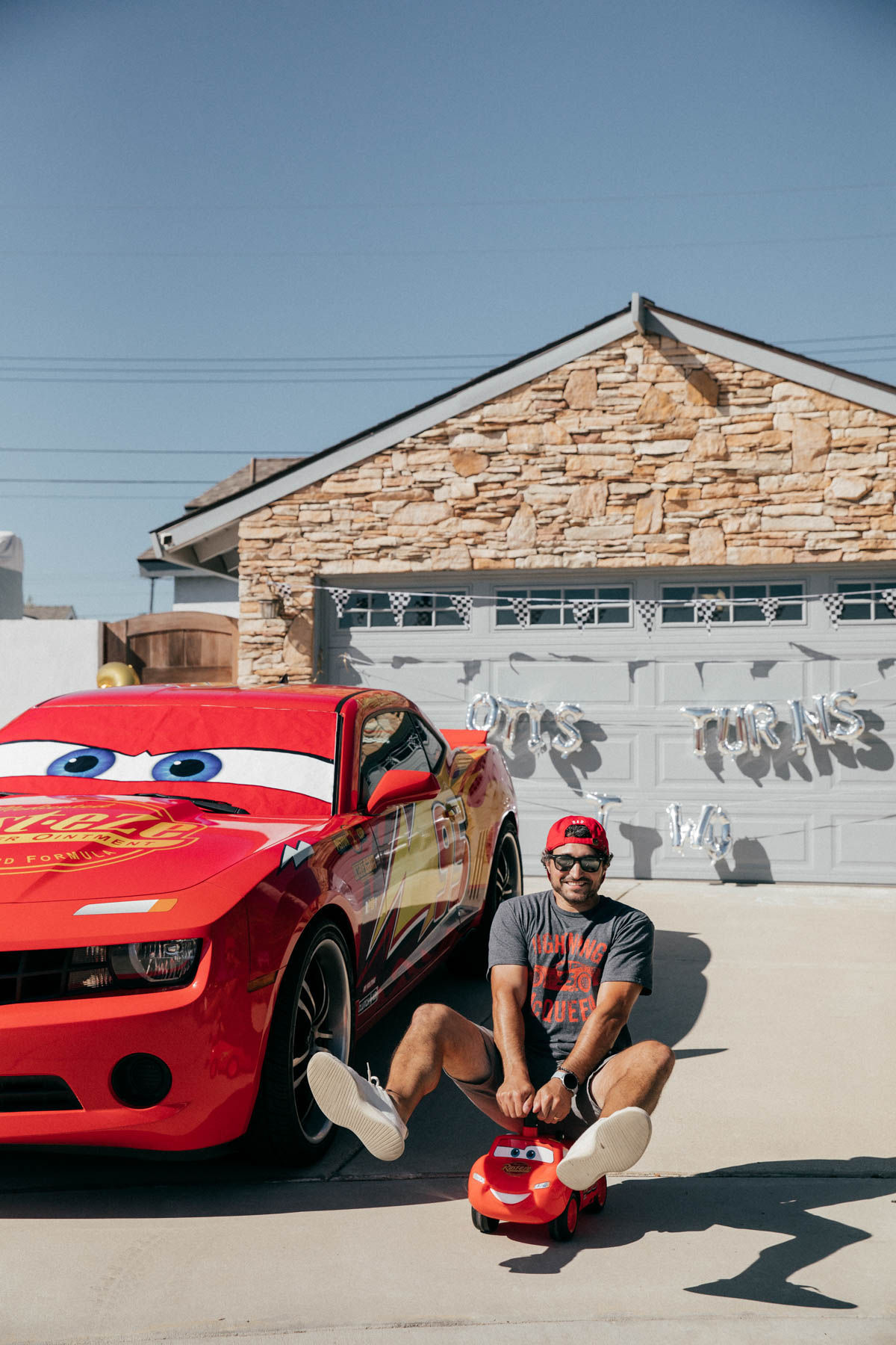 Lightning McQueen Impersonator Car and adult on Ride on Lightning McQueen Car Toy at Disney Pixar Cars themed birthday