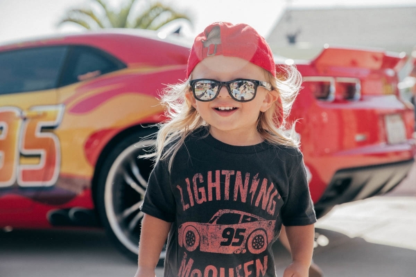 Toddler smiling in front of Lightning McQueen Impersonator at Disney Pixar Cars themed birthday