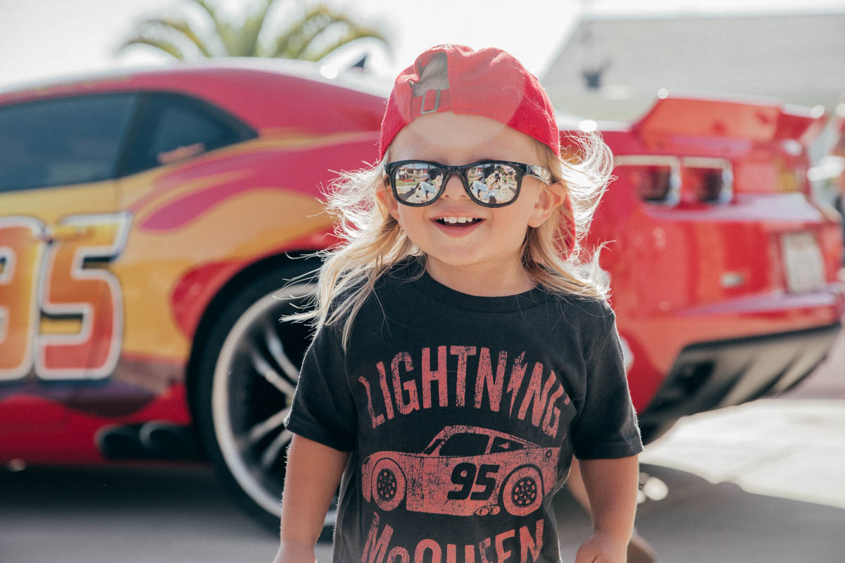 Toddler smiling in front of Lightning McQueen Impersonator at Disney Pixar Cars themed birthday