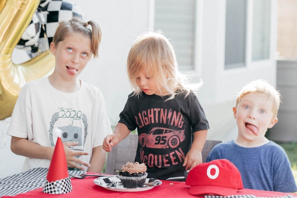 Family Singing Happy Birthday with Cupcake and race car theme decorations at Disney Pixar Cars themed birthday
