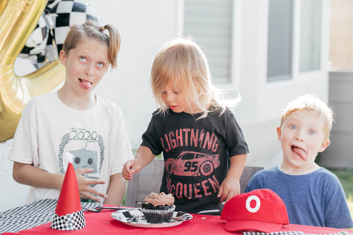 Family Singing Happy Birthday with Cupcake and race car theme decorations at Disney Pixar Cars themed birthday