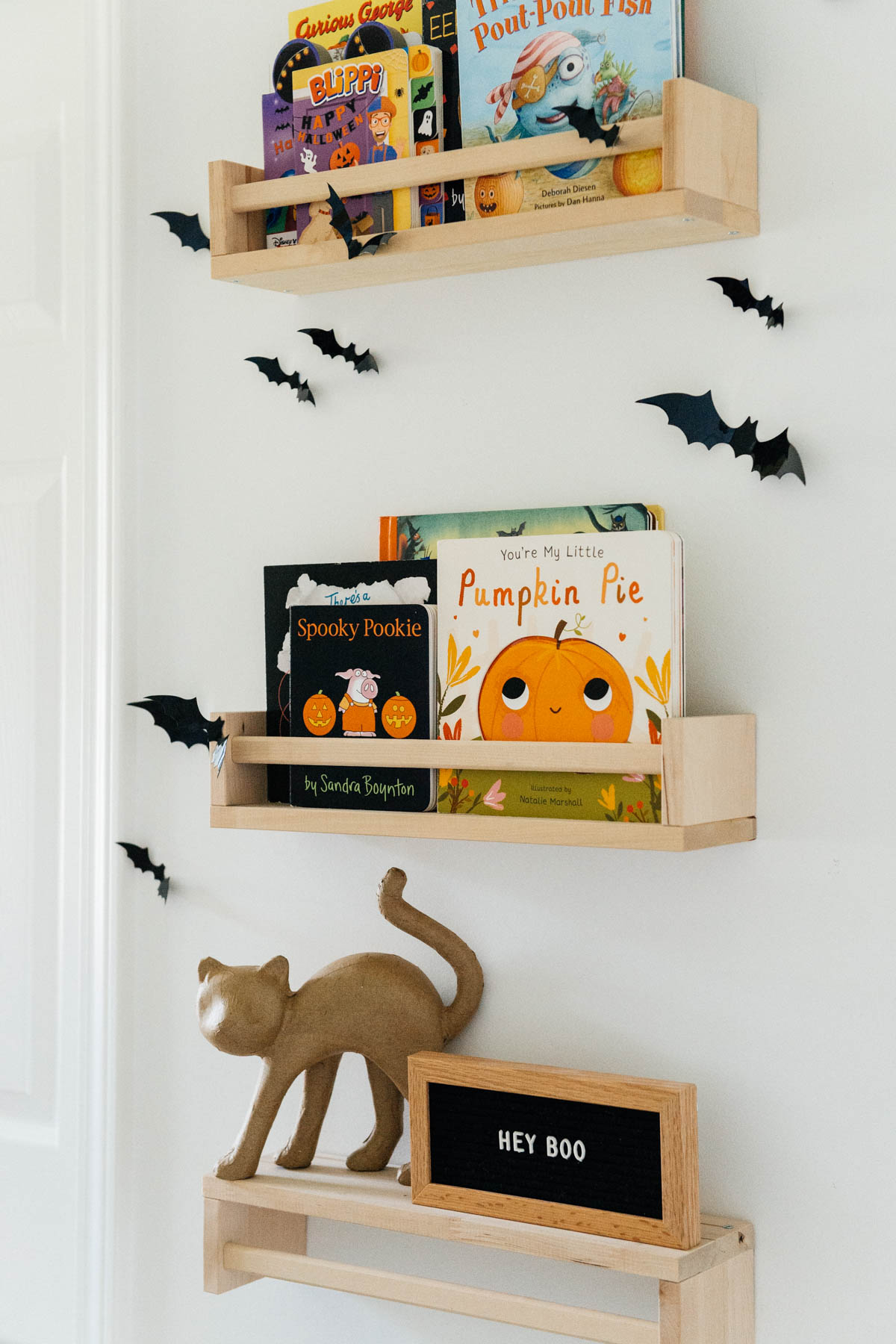 Best Halloween Books for Toddlers styled on wooden shelves with bat wall decals